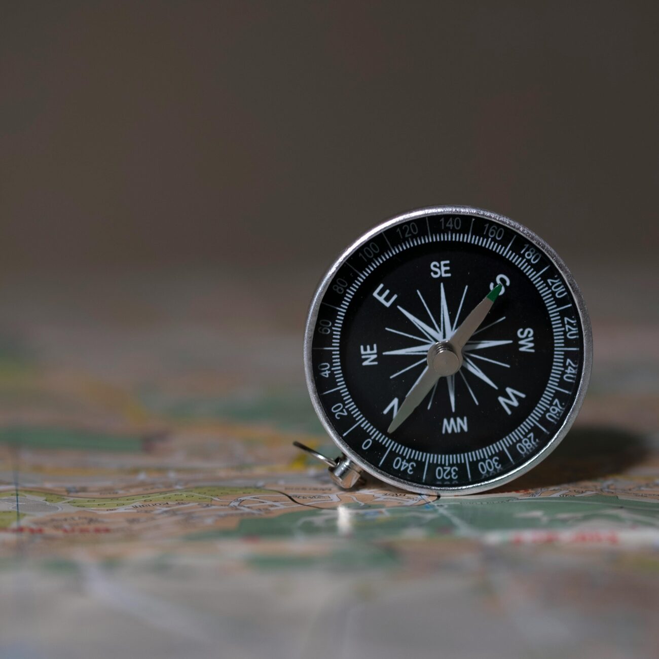 A detailed image of a compass on a map, symbolizing navigation and exploration.